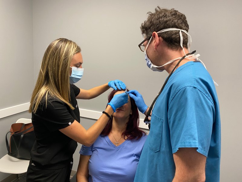 A photo of Nichole and Dr. Dan Landmann doing a Baby Botox on a female patient.
